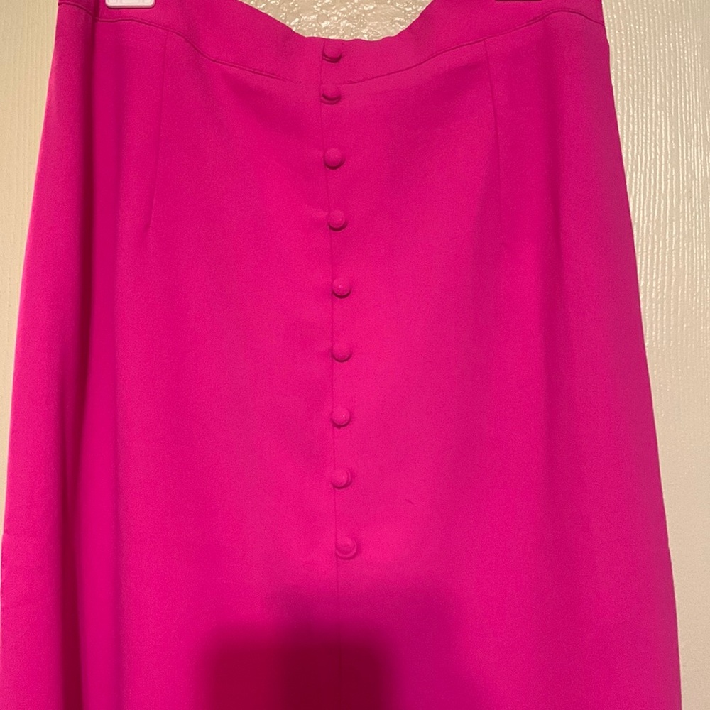 Hot pink button down skirt with a slit in the front.
